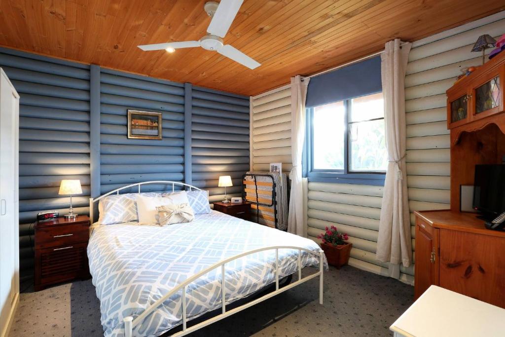 a bedroom with a bed and a blue wall at Chloes Cabin Accommodation in White Beach
