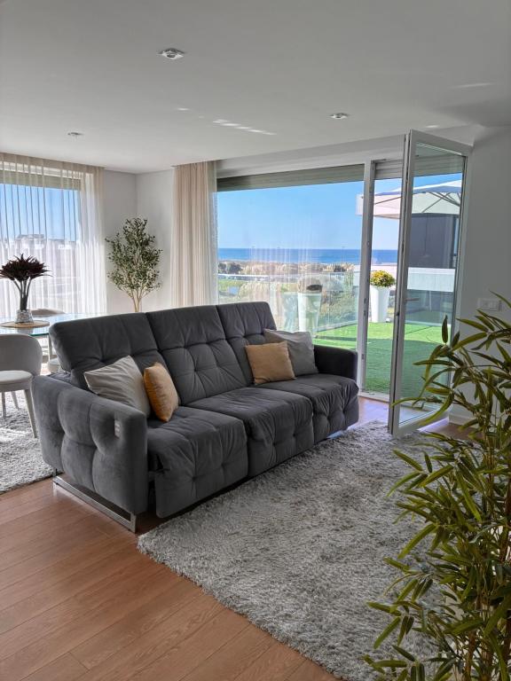 a black leather couch in a living room with glass doors at Luxury by the Blue in Vila Nova de Gaia