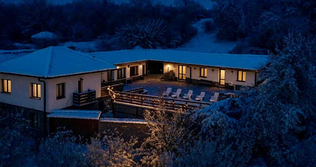 a house lit up in the snow at night at Han Gozdeika in Gozdeyka