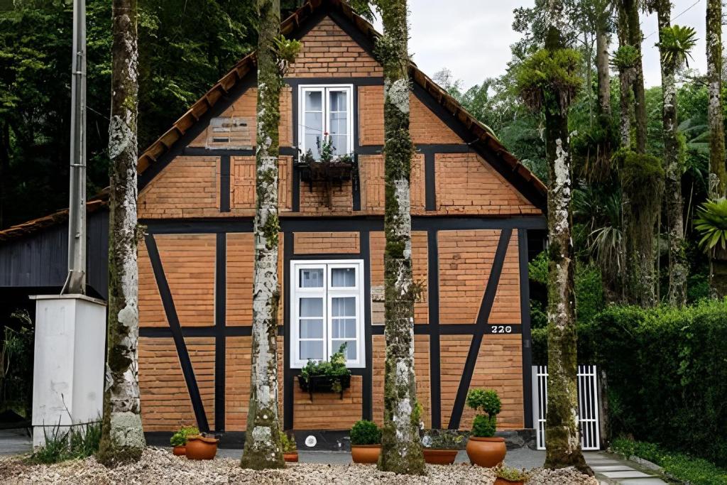 a house with trees in front of it at Casa Enxaimel em Pomerode SC 01 in Pomerode