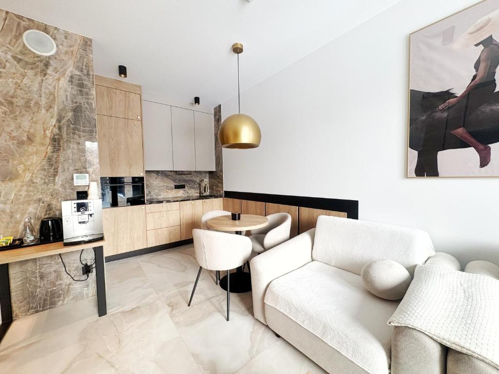 a living room with a couch and a table at Apartament - Vidok 301 in Olsztyn