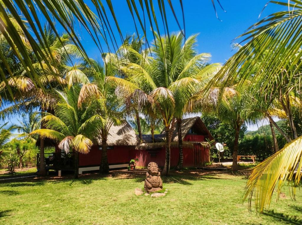 a statue sitting in the grass in front of a house at Fare PEA ITI Romantic Lodge in Patio