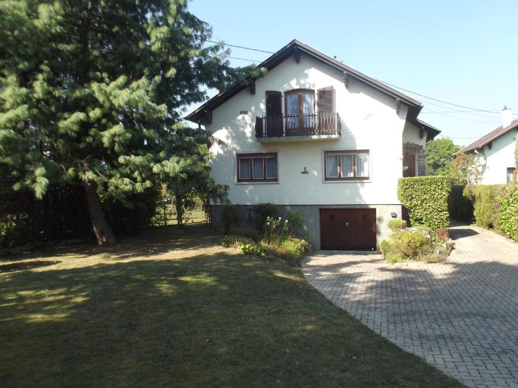 a white house with a balcony and a driveway at Les Sources de Saverne in Saverne