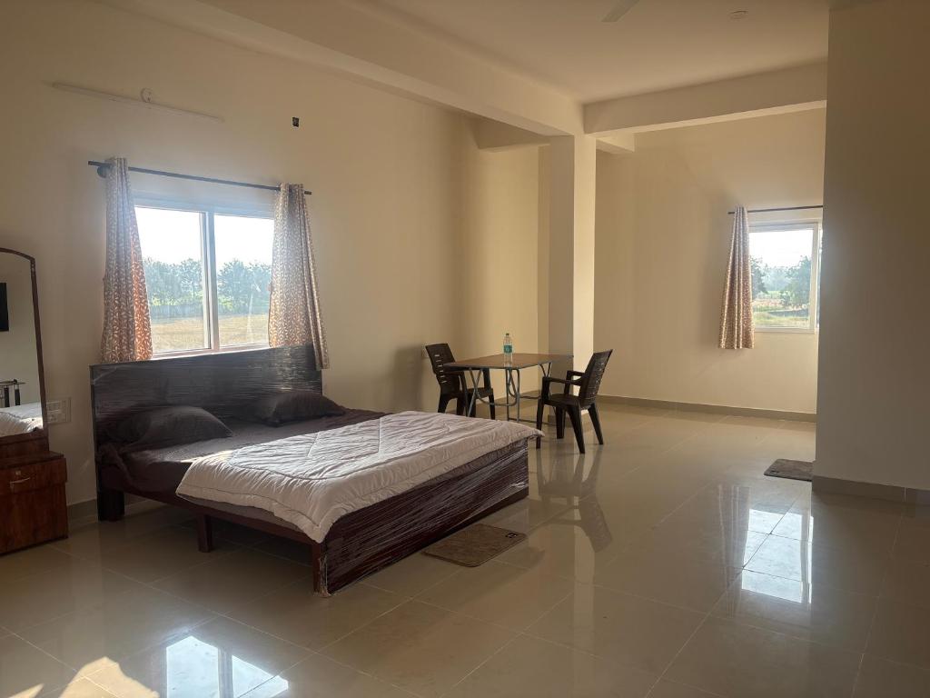 a bedroom with a bed and a table with chairs at Laya hotels in Chintāmani