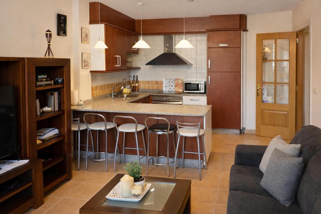 a kitchen and living room with a counter and bar at Winahost Ático Viveiro in Viveiro