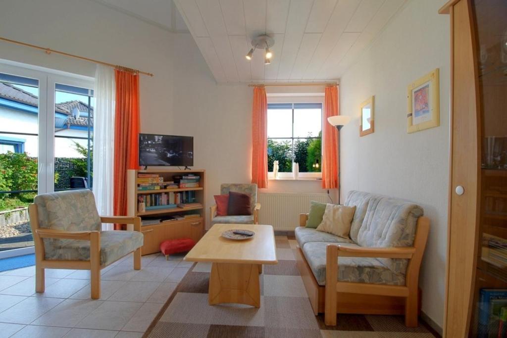 a living room with a couch and a table at STW24a Bungalow in Dorum-Neufeld