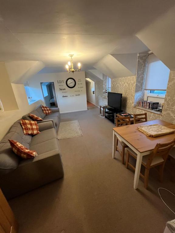 a living room with a couch and a table at Station apartment in Llanberis