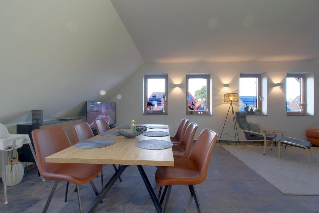 a dining room with a table and chairs at WK7 "Ferienwohnung Küstenruhe" in Dorum