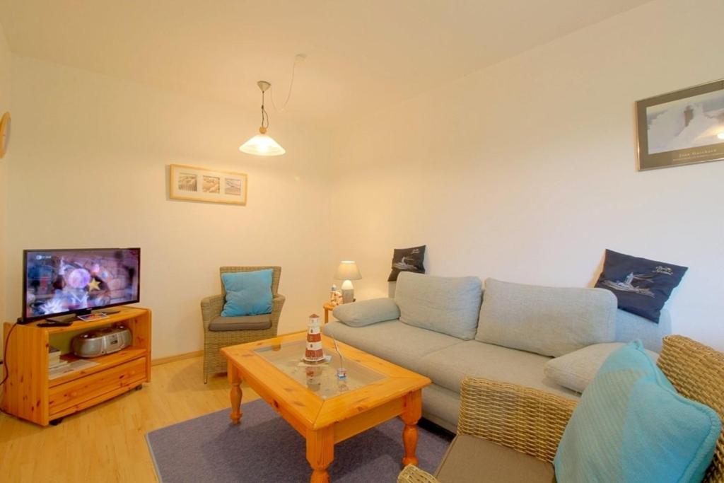 a living room with a couch and a tv at Lilli Marleen WE 26 in Wremen