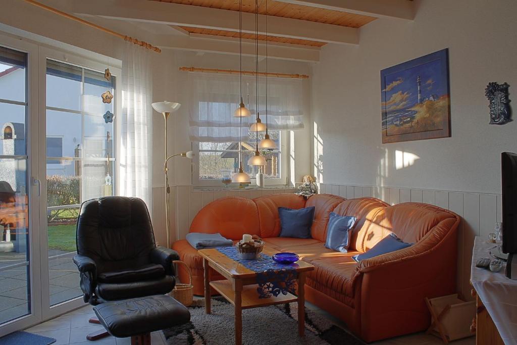a living room with a leather couch and a table at STW45b Bungalow Seestern in Dorum-Neufeld