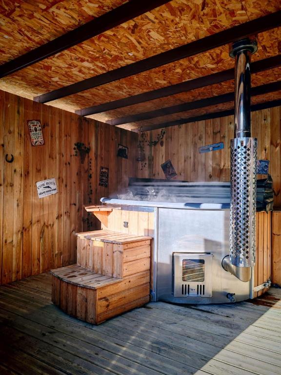 a kitchen with a stove in a wooden building at Le Ranch Normand in Les Cresnays