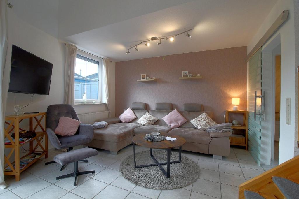 a living room with a couch and a chair at LT 33 Bungalow Manu in Dorum-Neufeld