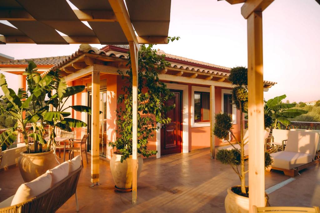 an outdoor patio with chairs and potted plants at Ananda Apartments in Skafidia