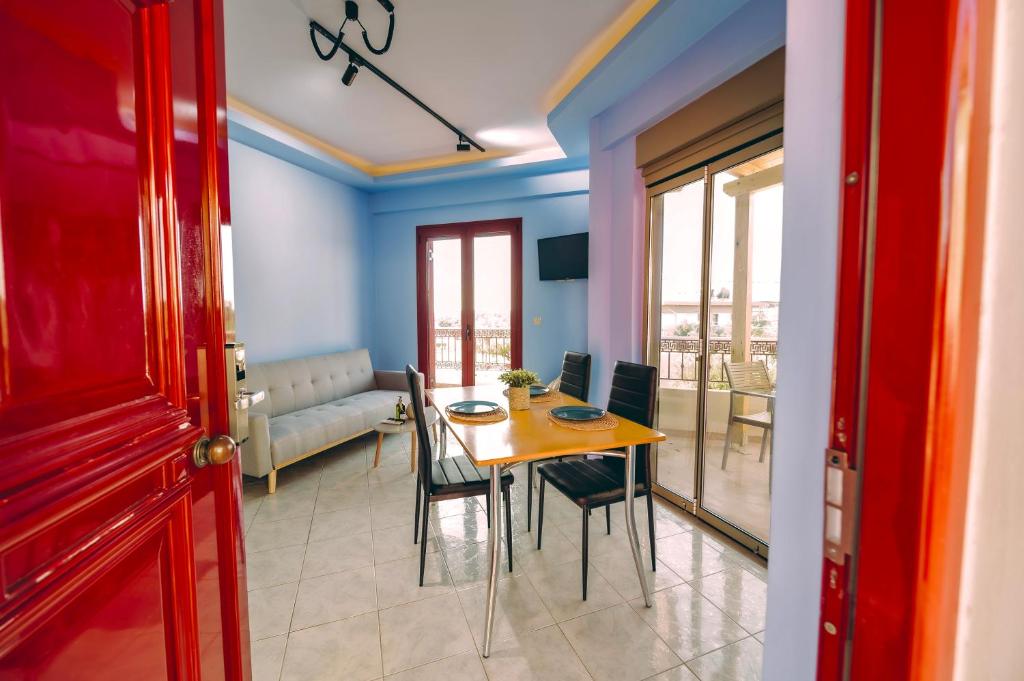 a dining room and living room with a table and chairs at Ananda Apartments in Skafidia