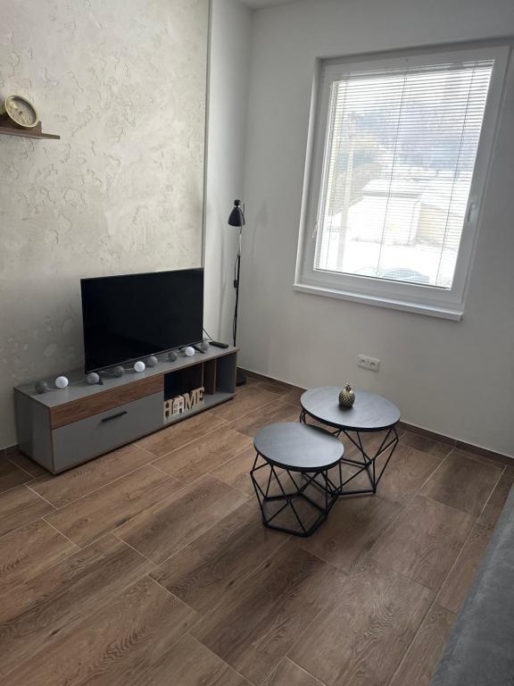 a living room with two tables and a flat screen tv at Apartmán ALEX Choceň in Choceň