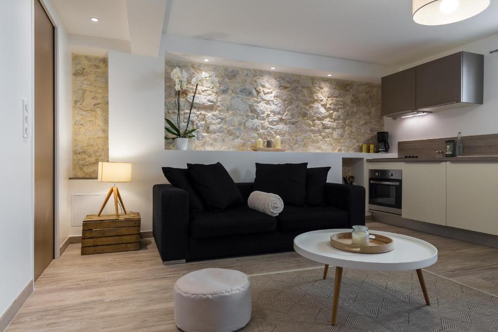 a living room with a black couch and a table at Cosy Home in Antibes