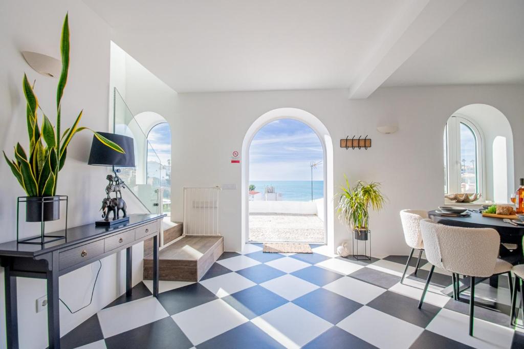 a living room with a table and chairs and the ocean at 14 Travessa das Naus in Carvoeiro