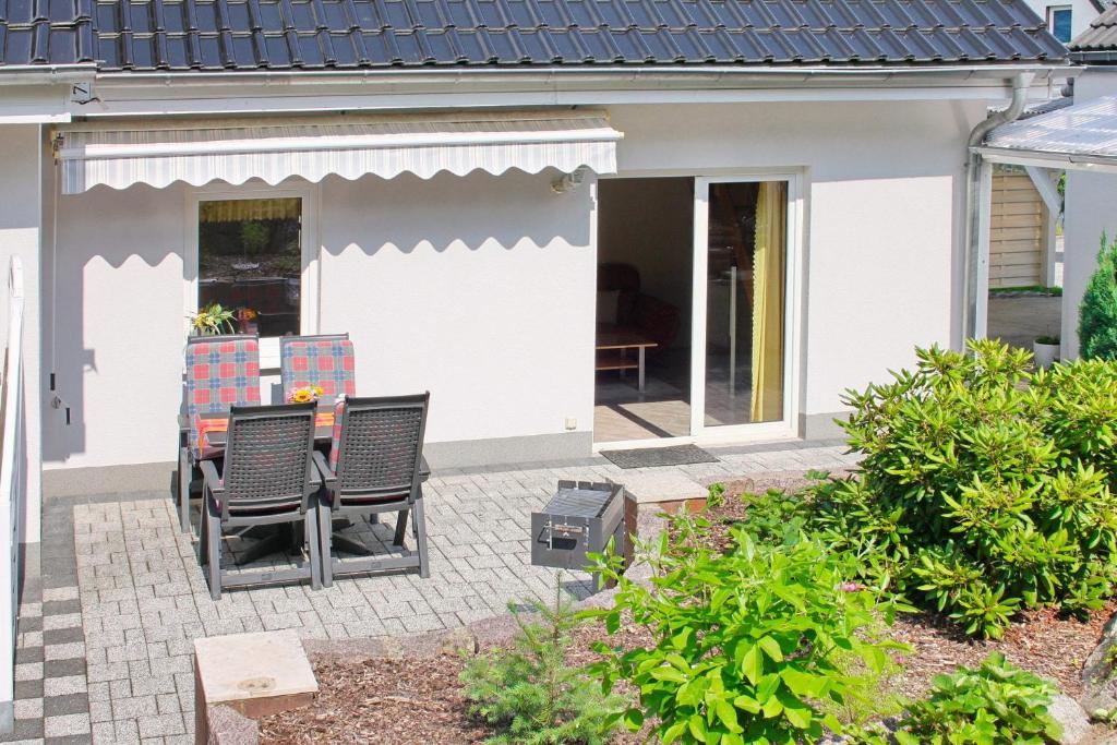 a patio with chairs and a grill in front of a house at Herz in Lübbenau