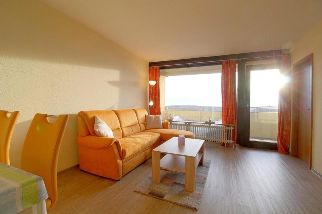 a living room with an orange couch and a table at Apartment 545 in Hohegeiß