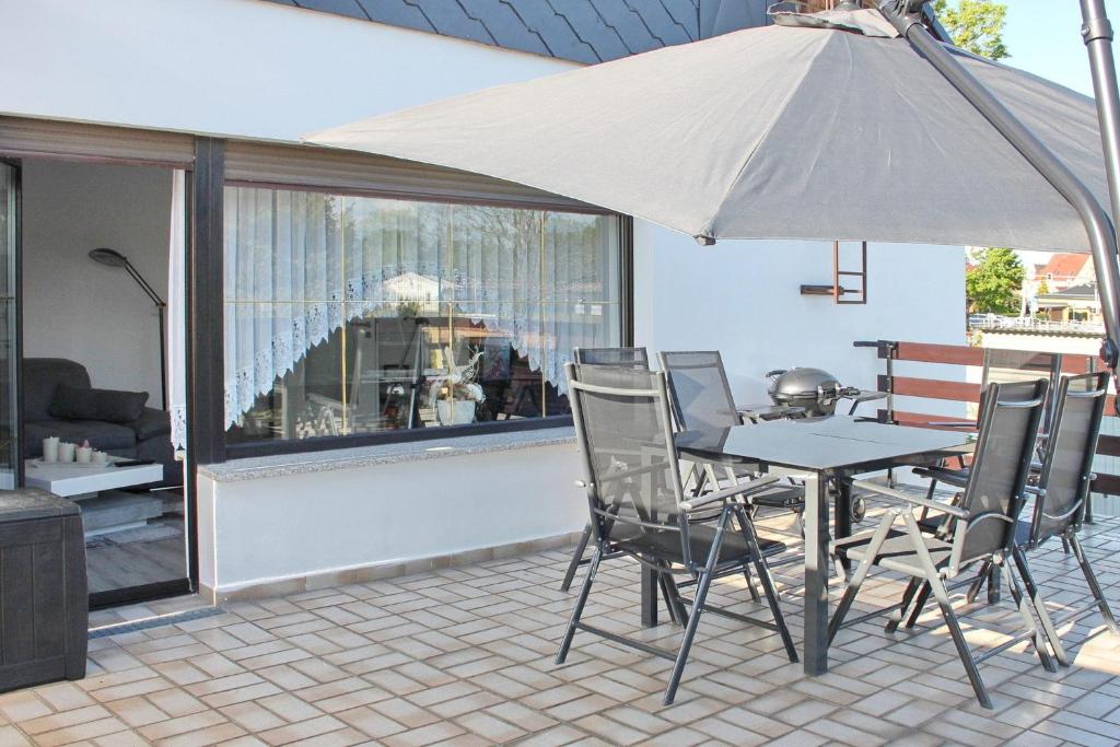 a table and chairs with an umbrella on a patio at Spreemitte in Lübbenau