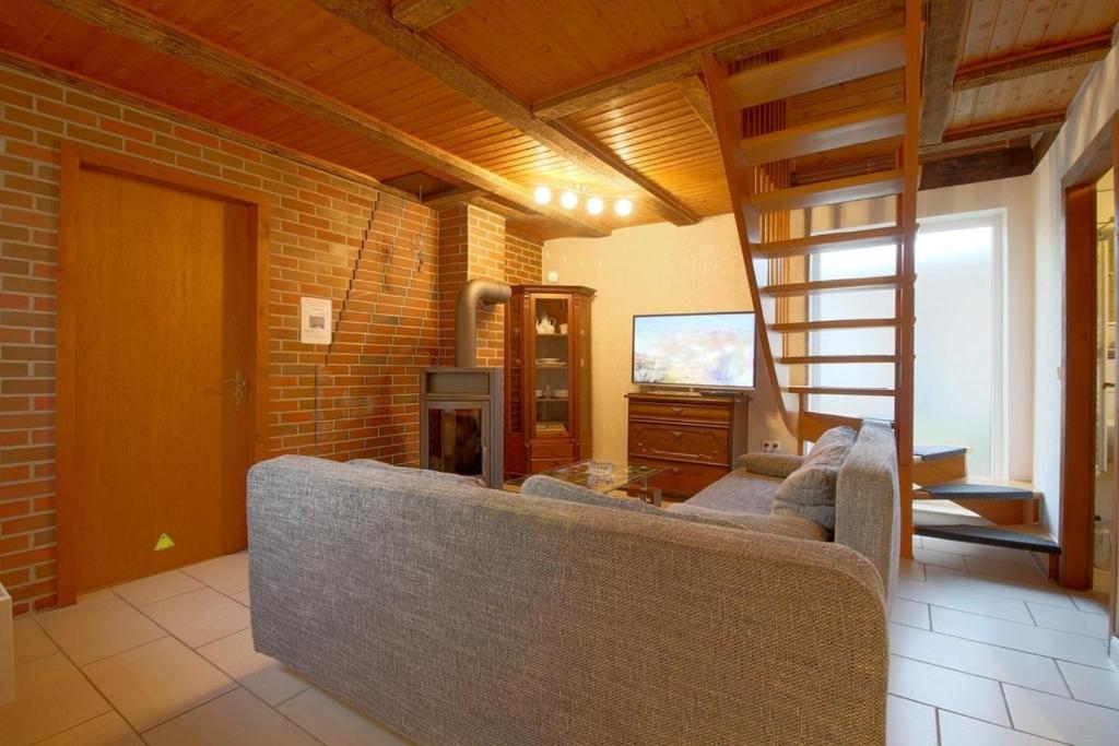 a living room with a couch and a television at Dat lütte Hus in Dorum