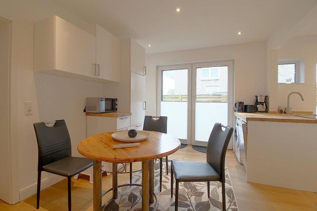 a kitchen and dining room with a table and chairs at NS 6 Strandläufer Wremen in Wremen