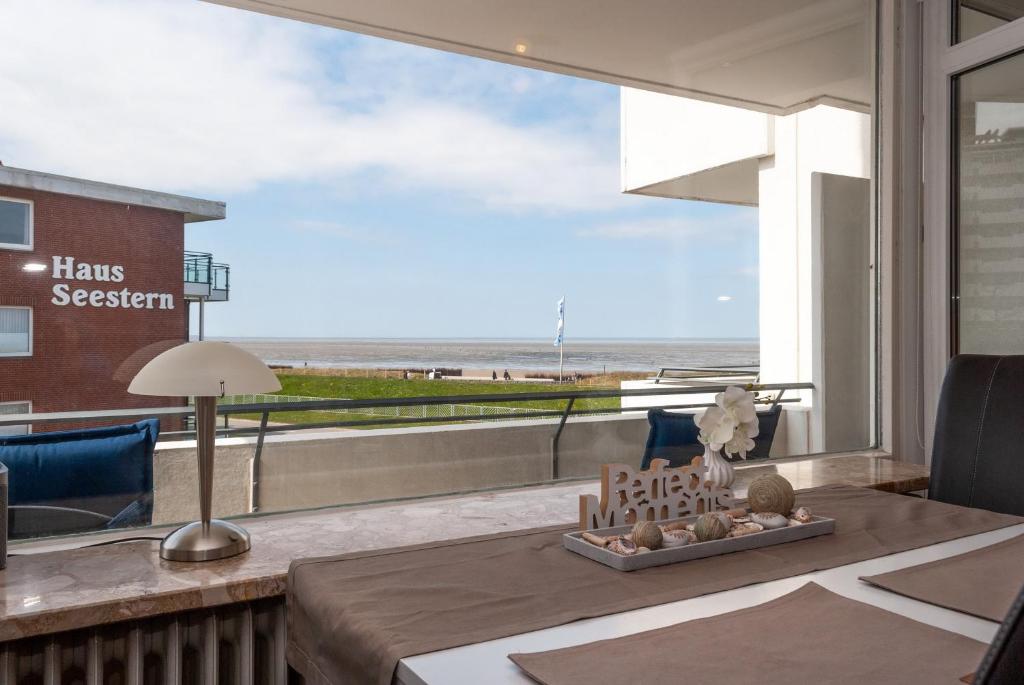 a living room with a table with a view of the beach at Hanseatic 204 in Duhnen