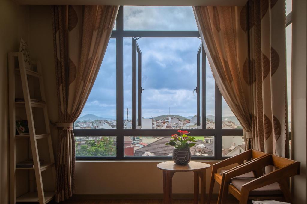 a room with a window with a vase of flowers on a table at Tasme Dalat Stay in Da Lat