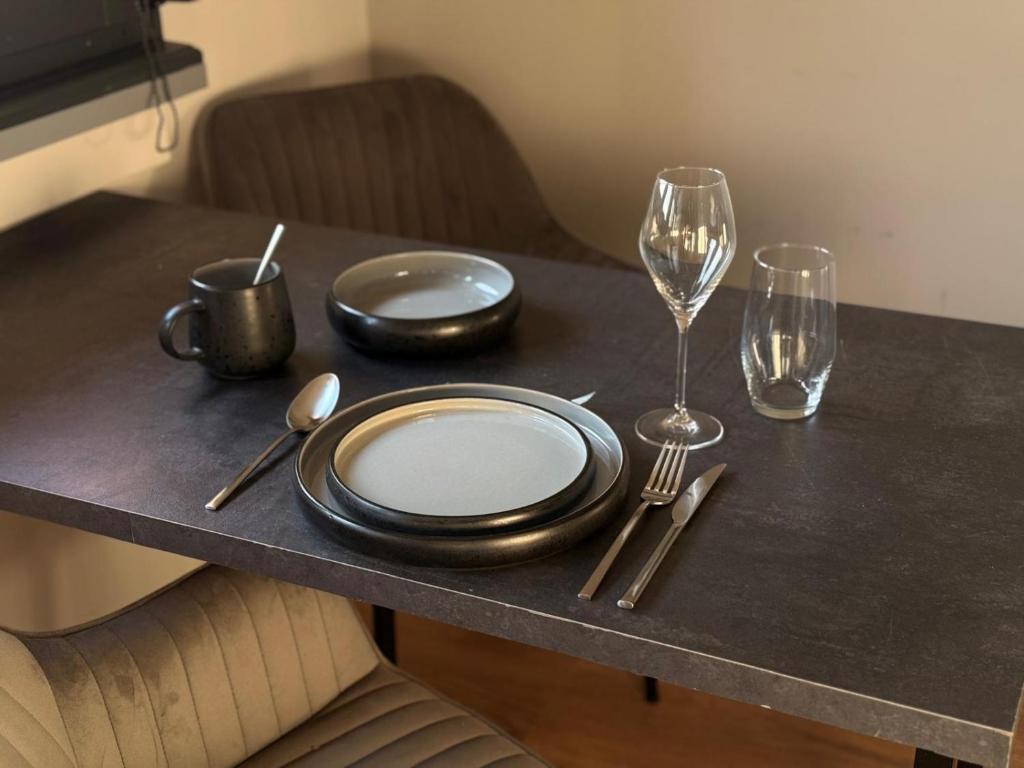 a table with plates and forks and glasses on it at Wohnung im Zentrum von Gaggenau! in Gaggenau