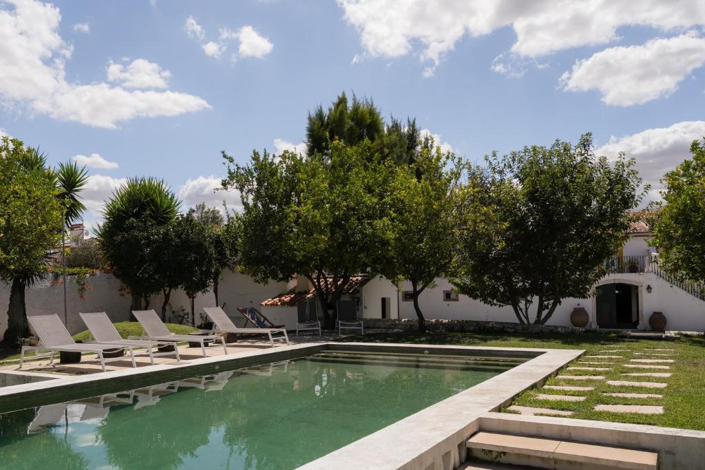 a swimming pool with lounge chairs and trees at Eighteen21 Houses - Casa dos Condes in Cano