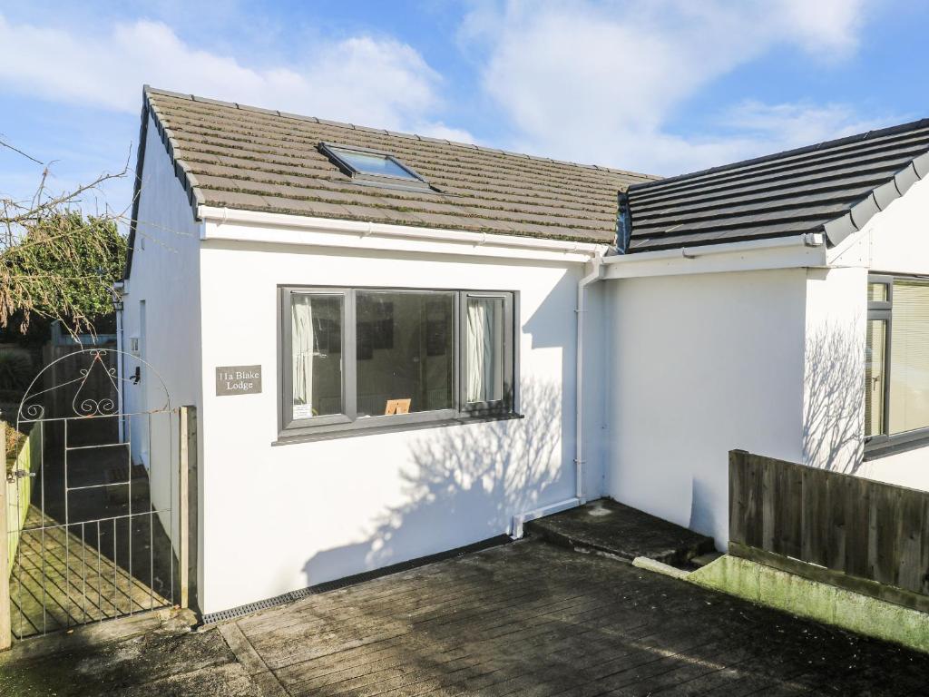 a white house with a gate and a fence at Blake Lodge in Newquay