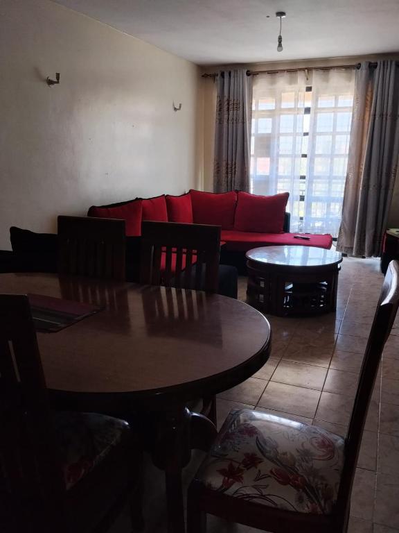 a living room with a red couch and a table at Westerville Apartments in Kitengela 