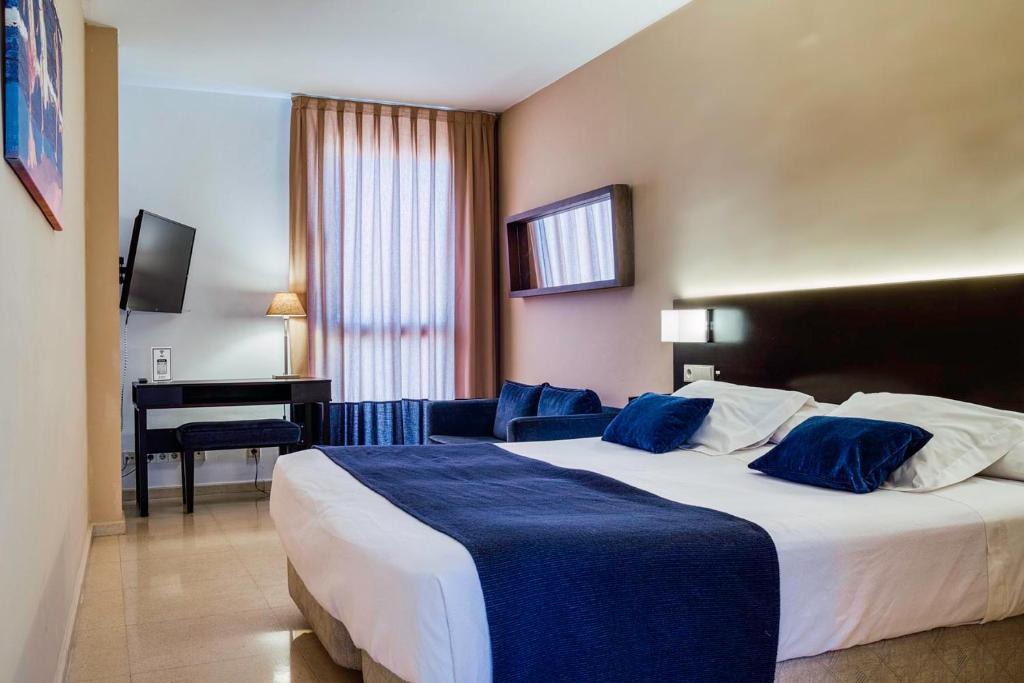 Una habitación de hotel con una cama grande y un escritorio. en Hotel Ignacio - PalomarGroup, en Chiva