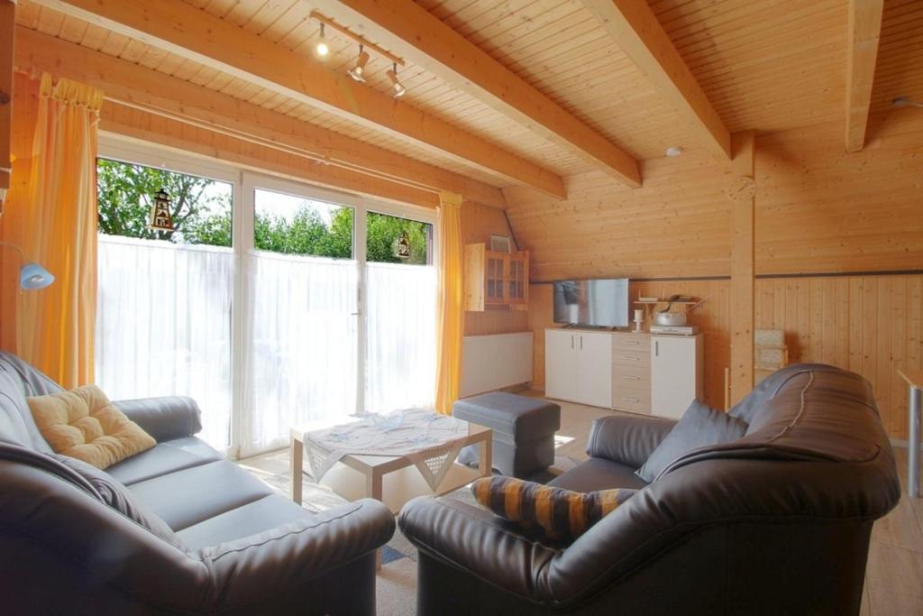 a living room with two leather couches and a table at SR Eversand 11 in Dorum-Neufeld
