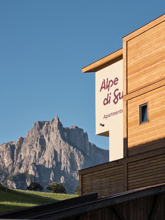 a sign on a building with a mountain in the background at Alpe di Susi in Castelrotto