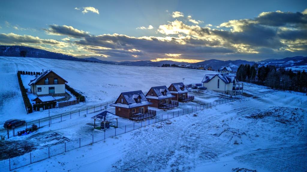 a group of houses in a snow covered field at Domki na Bukowinie in Węgierska Górka