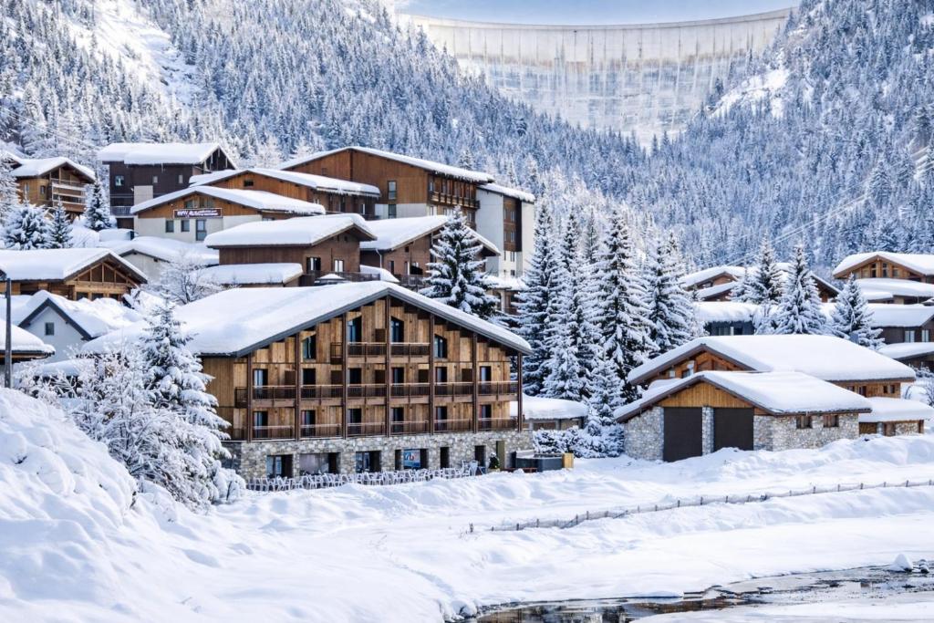 a resort in the snow with snow covered buildings at Hotel Tetras Lodge in Tignes