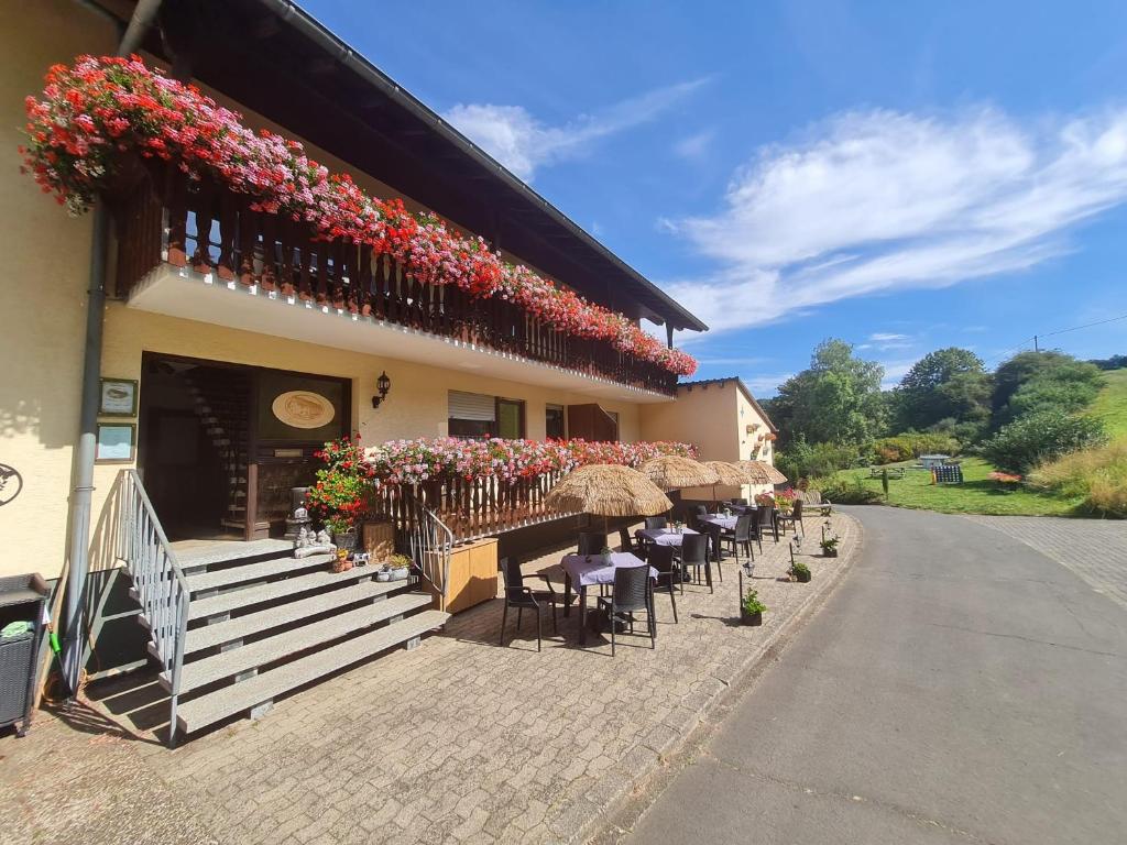 a restaurant with tables and chairs and flowers on the facade at Gasthaus Paula in Üdersdorf