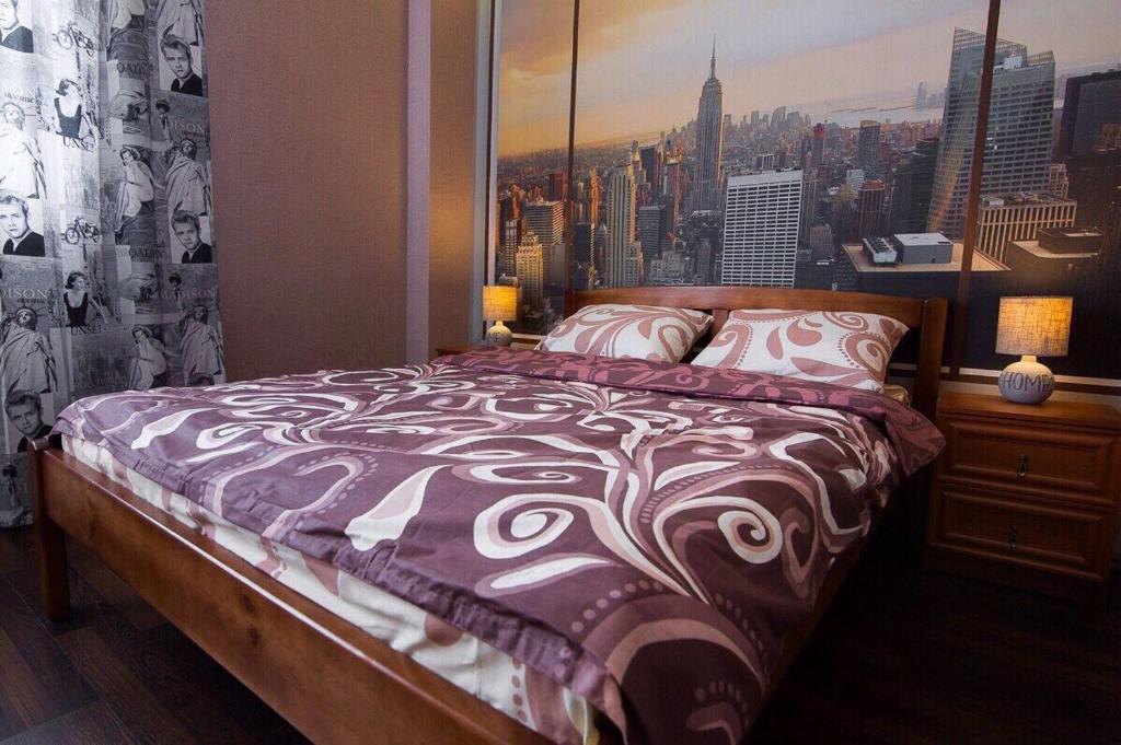 a bedroom with a bed with a view of a city at Apartment-Lawina in Sumy