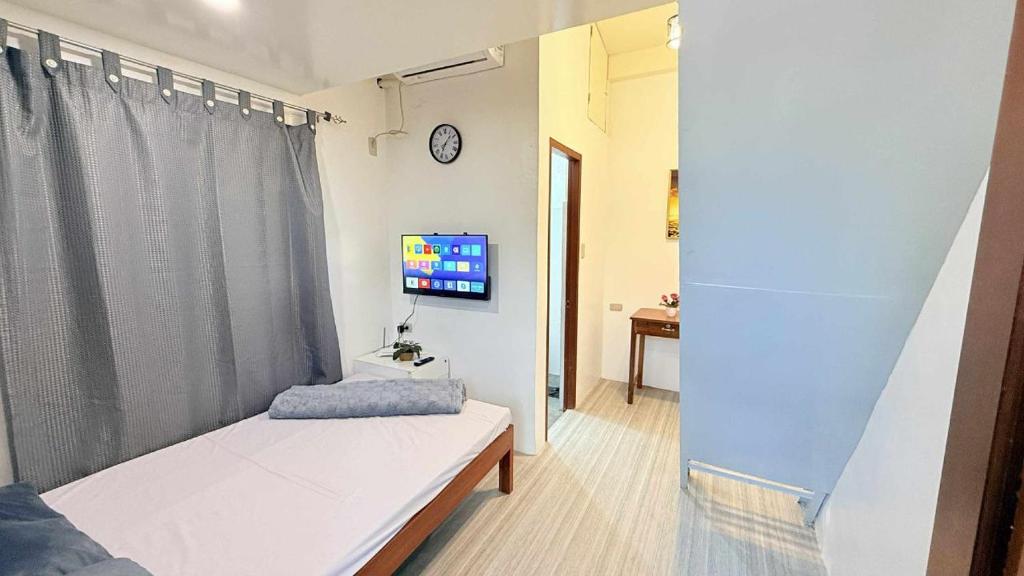 ein kleines Zimmer mit einem Bett und einem Fernseher in der Unterkunft Lucy's Tiny Homes in Puerto Princesa
