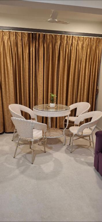 a table and chairs in front of a curtain at Soni & Avi View Apartment in Igatpuri