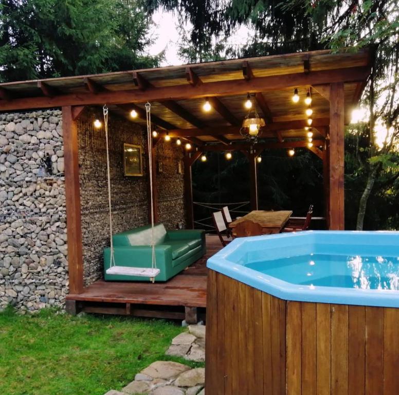 a hot tub on a wooden deck with a pergola at Casa Picătura de Rouă in Beliş