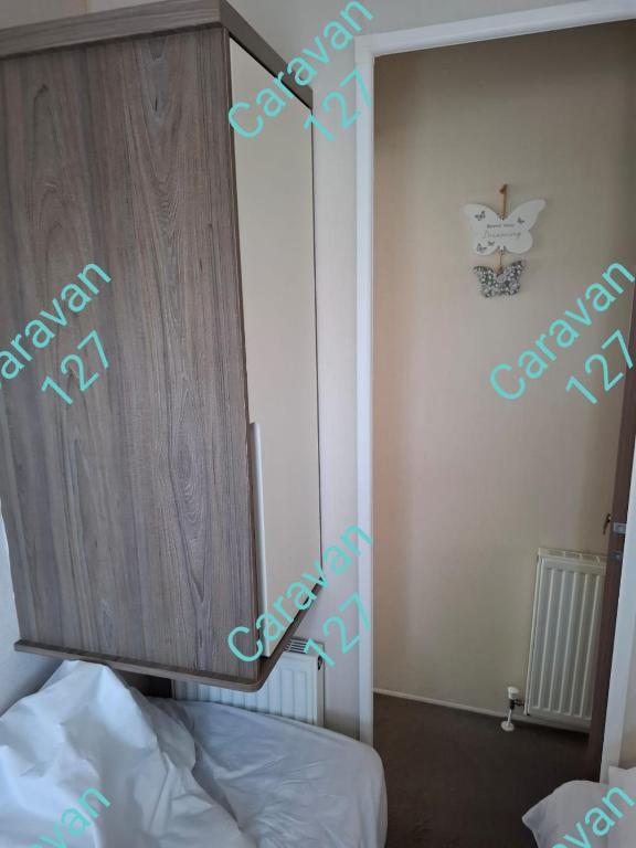 a bedroom with a cupboard and a bed in a room at Caravan 127 in Barmouth