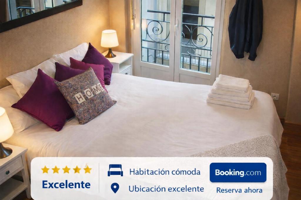 a bedroom with a bed with purple pillows at Balcón curva de Estafeta - Centro in Pamplona