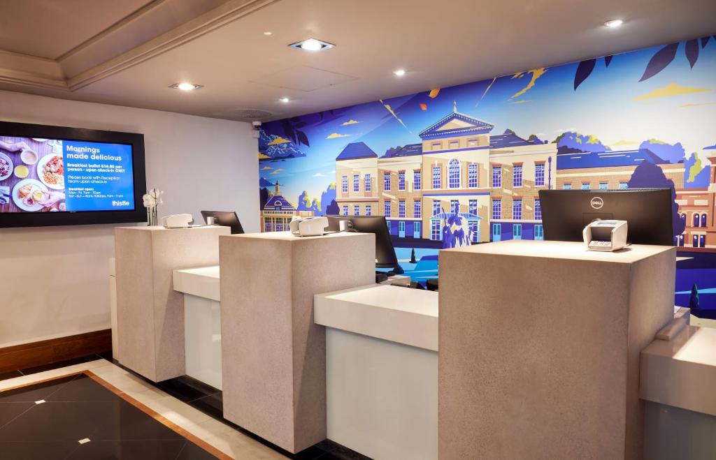 a room with a wall with a picture of a building at Thistle London Hyde Park Kensington Gardens in London