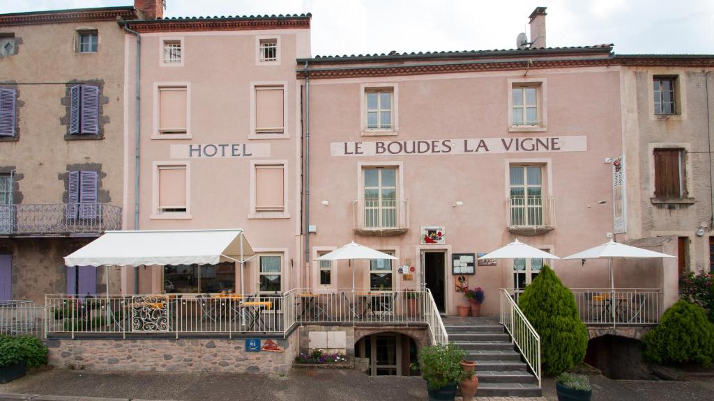 un edificio rosa con sombrillas blancas delante en Le Boudes la vigne, en Boudes