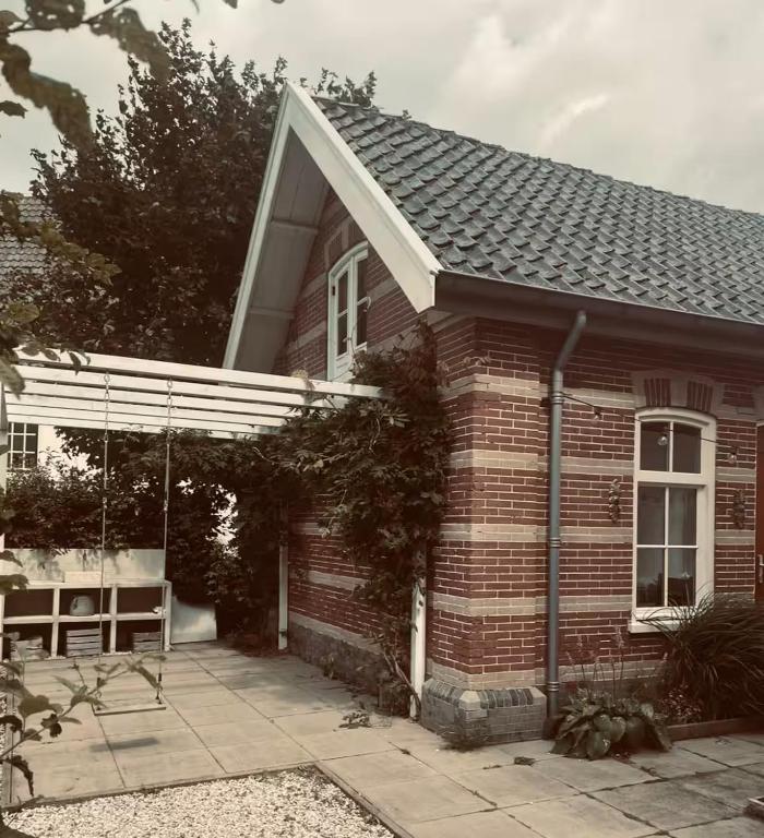 a red brick house with a white roof at Maison 1882 in Hauwert