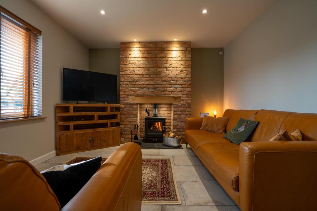 a living room with a couch and a fireplace at The Old Pitman's house in Ollerton