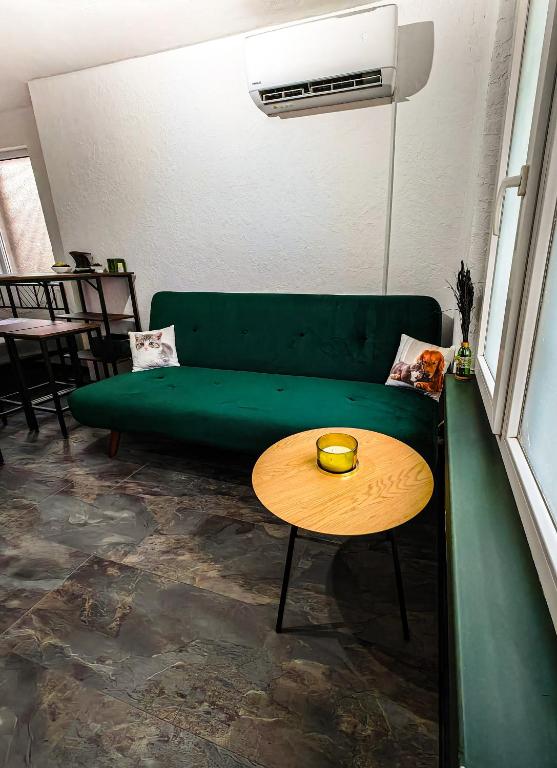 a green couch in a living room with a table at Studio Dimon in Pleven