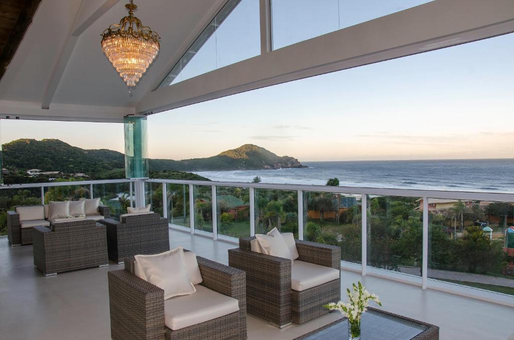 a living room with a balcony overlooking the ocean at Fazenda Verde - Praia do Rosa in Praia do Rosa